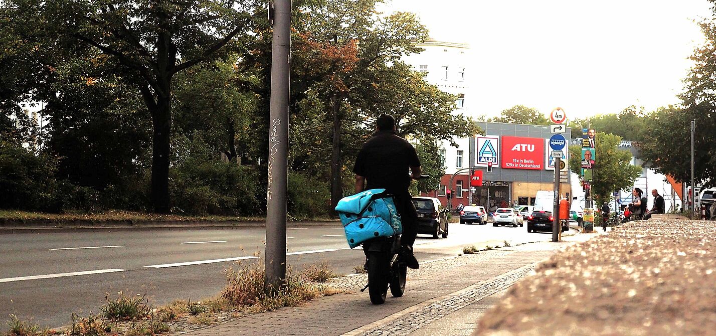 Lieferdienst-Fahrer:innen arbeiten oft unter prekären Bedingungen Lieferdienst-Fahrer auf dem Fahrrad transportiert eine Wolt-Transport-Box auf dem Gepäckträger