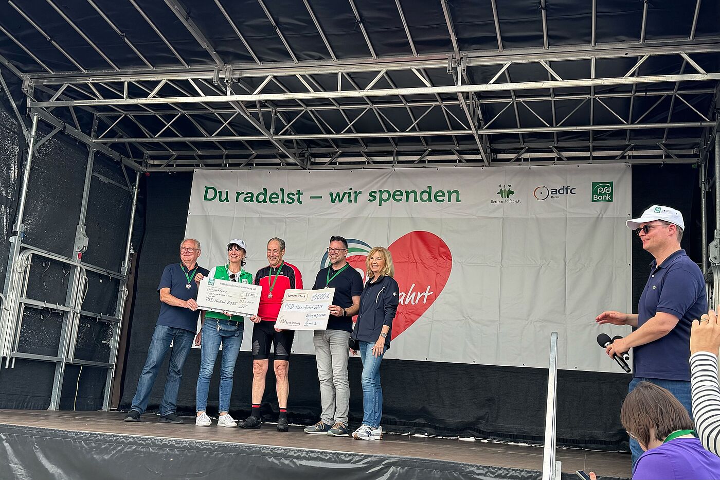 Übergabe von Spendenchecke bei der PSD Herzfahrt