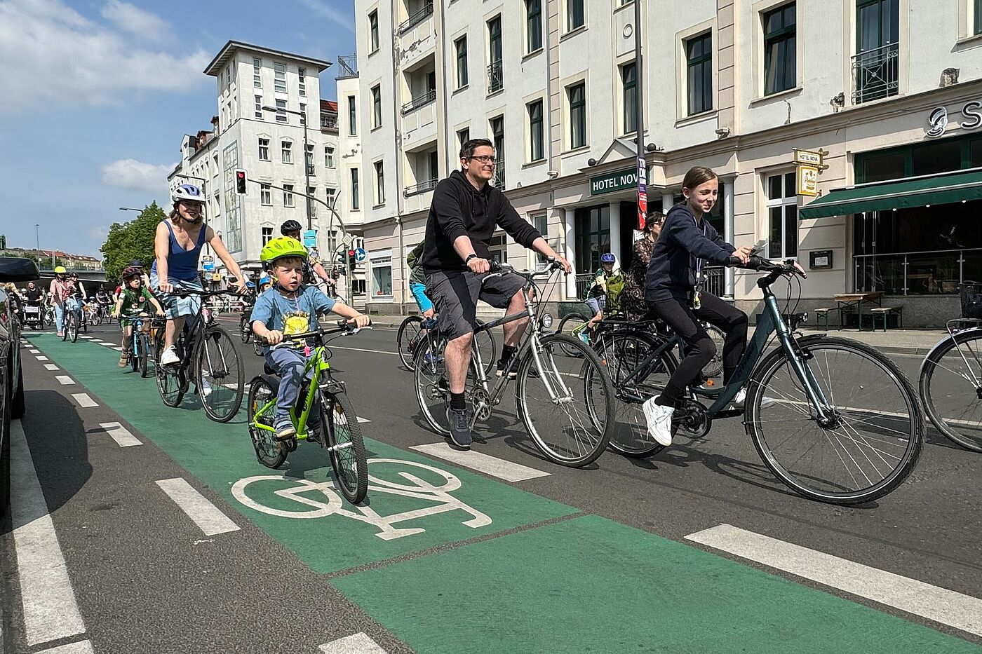 Erwachsene und Kinder fahren auf dem Fahrrad durch die Stadt