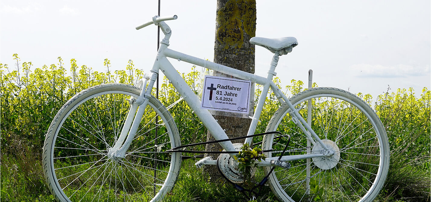 Ein weißes Geisterrad vor einem gelb blühenden Feld