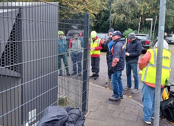 Heinfried Becker mit Interessierten vor einer Wärmepumpe in der Ellhorner Straße